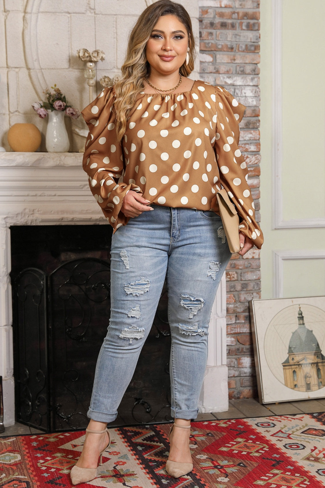 Model wearing Plus Size Polka Dot Blouse with distressed jeans and heels. Elegant long sleeves and soft fabric make it a chic everyday outfit.
